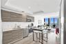 Kitchen featuring horizontal wood-grain cabinetry, stainless steel appliances, recessed ceiling lighting, and wood-finish flooring with floor-to-ceili