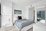 Neutral-toned wood-finish flooring, floor-to-ceiling window, and full-length wall mirror