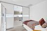 Floor-to-ceiling sliding panels with frosted glass inserts, built-in cabinetry, wood-finish flooring, and recessed ceiling lighting