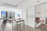 Open-concept floor plan featuring wood-finish flooring, floor-to-ceiling windows, recessed lighting, and a sliding glass door panel partition