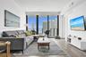 Living area featuring wood-finish flooring, floor-to-ceiling windows, and a private balcony