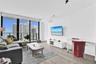 Floor-to-ceiling windows, wood-finish flooring, and a private balcony featuring a glass and metal railing