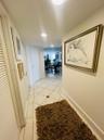 Hallway featuring large-format diagonal tile flooring with decorative stone accents and recessed ceiling lighting
