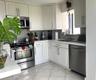 Kitchen featuring white shaker-style cabinetry, stainless steel appliances, subway tile backsplash, solid-surface countertops, and diagonal-set tile f