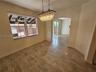 Stone-finish tile flooring, decorative multi-tier crystal chandelier, arched entryway, and double-pane window
