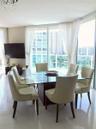 Floor-to-ceiling glass paneling, polished tile flooring, crystal chandelier, and wrap-around window configuration