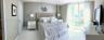 Floor-to-ceiling windows with neutral drapery, large-format tile flooring, and smooth-finish walls