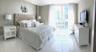 Floor-to-ceiling windows featuring urban scenery, complemented by polished light-toned tile flooring throughout