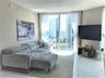 Floor-to-ceiling windows, polished white flooring, and neutral wall tones