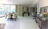 Open-concept living space featuring high-gloss tile flooring, floor-to-ceiling windows, and a built-in kitchen breakfast bar