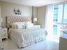 Floor-to-ceiling windows featuring exterior maritime scenery, paired with polished neutral-toned tile flooring