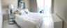 Spacious interior featuring white tile flooring, neutral wall tones, and glass sliding doors providing external access