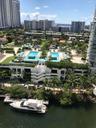 Aerial perspective featuring dual outdoor swimming pools, landscaped grounds, a boat dock, and waterfront access