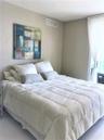 Neutral-toned interior featuring high-gloss tile flooring and natural light through floor-to-ceiling window treatments