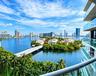 Private balcony with glass panel railing and panoramic waterfront and city skyline scenery