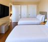 Room featuring wood-finish flooring, dual-door closet storage, and neutral wall tones