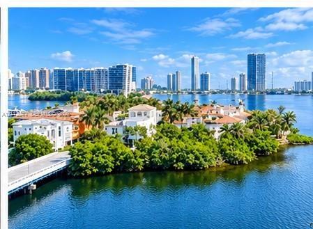 Waterfront estate featuring deep-water access, multi-story Mediterranean-style architecture, tile roofing, private bridge entry, and mature tropical l