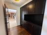 Dark wood built-in cabinetry featuring shaker-style doors, drawers, and open shelving, complemented by wood-finish flooring and crown molding