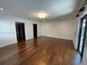 Wide-plank wood-finish flooring, recessed ceiling lighting, decorative flush-mount light fixture, and black-framed glass sliding doors