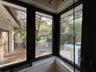 Multi-pane corner windows with black frames and exterior scenery