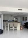 Kitchen featuring white cabinetry, a tiled backsplash, a central island, track lighting, and white tile flooring