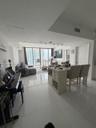 Open-concept interior featuring large-format tile flooring, floor-to-ceiling glass windows, and a built-in kitchen island with integrated wine storage