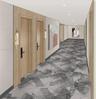 Hallway featuring light wood-finish door frames, recessed ceiling lighting, patterned wall-to-wall carpeting, and wall-mounted metallic sconces