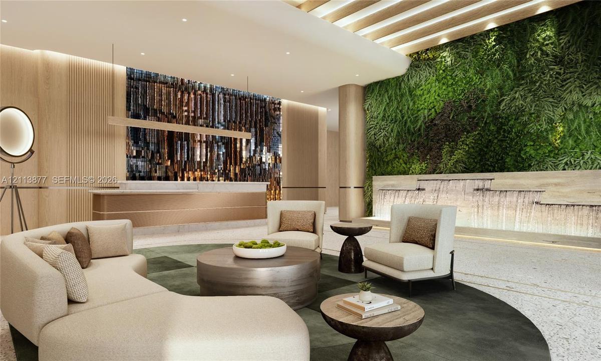 Lobby featuring a built-in stone service desk, textured wood-paneled walls, a multi-tiered stone water feature, and a vertical garden wall with integr