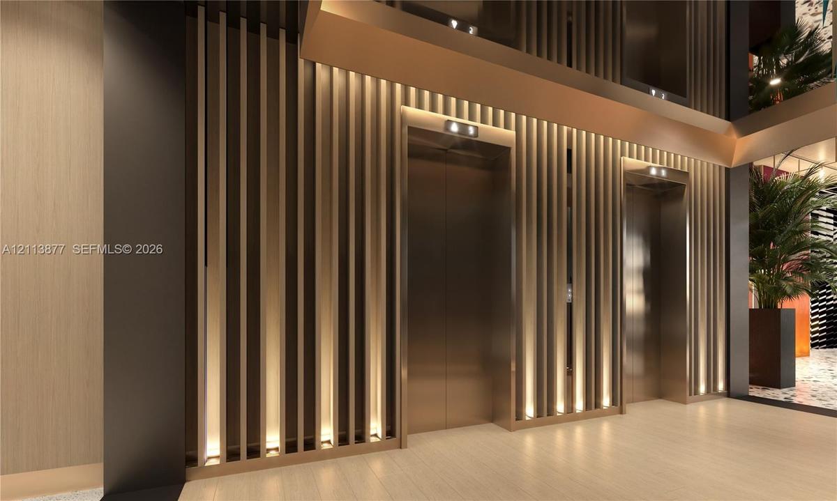 Floor-to-ceiling slatted wall paneling with integrated vertical accent lighting, metallic elevator doors, and neutral wide-plank flooring