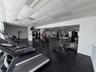 Fitness center featuring black rubber flooring, wall-to-wall mirrors, and a suspended drop ceiling