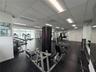Fitness center featuring floor-to-ceiling mirrors, drop-ceiling grid lighting, large-format rubber flooring, and expansive windows