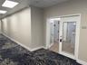 Entryway featuring a single door with a glass inlay, neutral wall paint, wood-finish flooring, and drop ceiling panels with recessed lighting