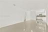 Neutral-toned tile flooring, white cabinetry, integrated stone-finish countertops, and flush-mount ceiling lighting
