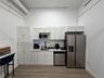 Kitchenette featuring white Shaker-style cabinetry, high-contrast matte black faucet, stone-finish countertops, stainless steel dishwasher, and matchi