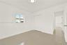 Neutral-toned tile flooring, white interior walls, sliding door closet, single-pane window, and flush-mount ceiling lighting