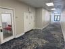 Hallway featuring patterned carpeting, recessed ceiling lighting, and multiple secure-entry doors