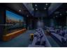 Dedicated media room featuring a large-format projection screen, recessed ceiling lighting, wall-integrated acoustic paneling, and a custom built-in w