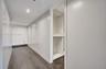 Floor-to-ceiling built-in cabinetry with a smooth white finish, integrated closet shelving, recessed ceiling lighting, and dark wood-finish flooring