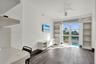 Wood-finish flooring, floor-to-ceiling windows, built-in shelving, white media console, and ceiling fan