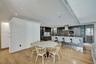 Contemporary kitchen featuring custom cabinetry, integrated stainless steel appliances, a large stone-topped island with seating, recessed ceiling lig