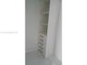 Built-in cabinetry featuring white shelving, five drawers, and metallic hardware