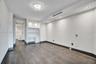 Wood-finish flooring, built-in cabinetry with integrated desk space, recessed ceiling lighting, and a decorative modern chandelier