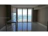 Floor-to-ceiling sliding glass doors, polished tile flooring, and private balcony with railing