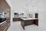 Kitchen featuring flat-panel cabinetry, a central island with a solid-surface countertop, recessed ceiling lighting, pendant light fixtures, and polis
