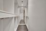 Custom floor-to-ceiling cabinetry, dark wood-finish flooring, full-length mirror, and recessed ceiling lighting