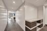 Hallway featuring wood-finish flooring, extensive floor-to-ceiling built-in cabinetry with a seamless finish, recessed ceiling lighting, and a custom 