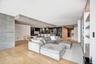 Open-concept interior featuring light wood-finish flooring, floor-to-ceiling stone accent wall, recessed lighting, integrated wine refrigeration, and 