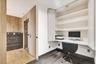 Built-in wall desk with overhead shelving, wood-finish flooring, wood wall paneling, and a dedicated alcove entry