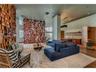 Open-concept living space featuring high ceilings, a prominent floor-to-ceiling geometric wood-toned feature wall, wood-finish flooring, and a built-i