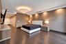 Wood-finish flooring, recessed ceiling lighting, textured wall finish, integrated linear HVAC diffusers, and a low-profile circular overhead fixture